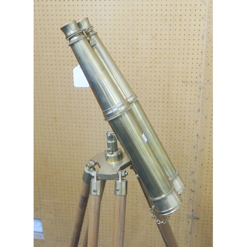 560 - A pair of modern brass decorative binoculars, mounted upon a hardwood tripod, measuring approx. 125c... 