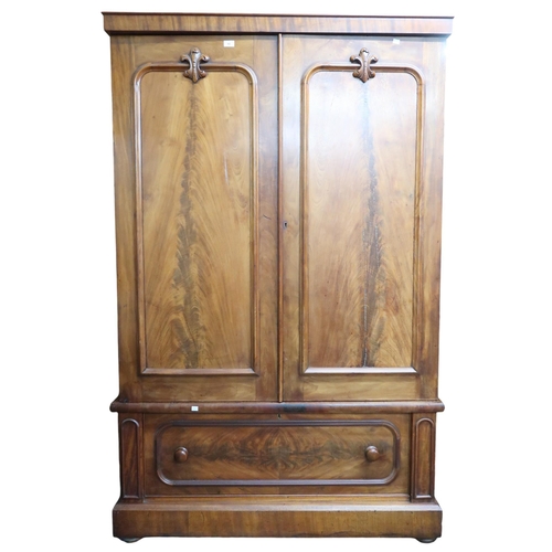 18 - A Victorian mahogany two door wardrobe on single drawered base on bun feet, 202cm high x 128cm wide ... 