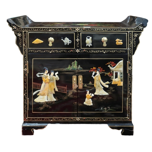 25 - A 20th century Chinese black lacquer side cabinet with painted top over two short drawers over pair ... 