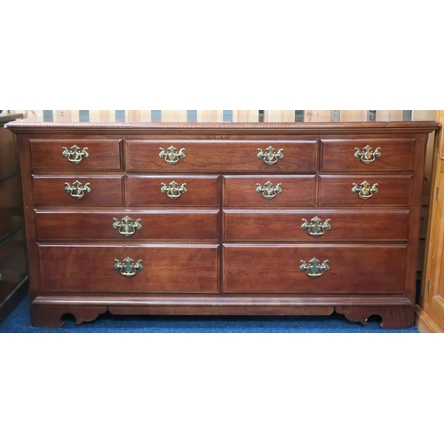 57 - A 20th century mahogany bank of drawers with brass drawer pulls on bracket feet, 81cm high x 157cm w... 