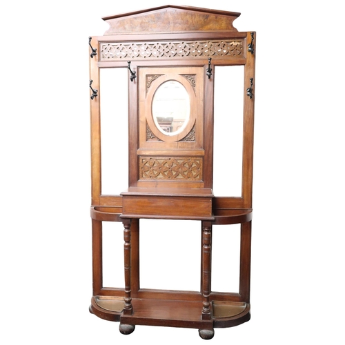 6 - An early 20th century mahogany and walnut veneered mirror backed hall stand with central oval bevell... 