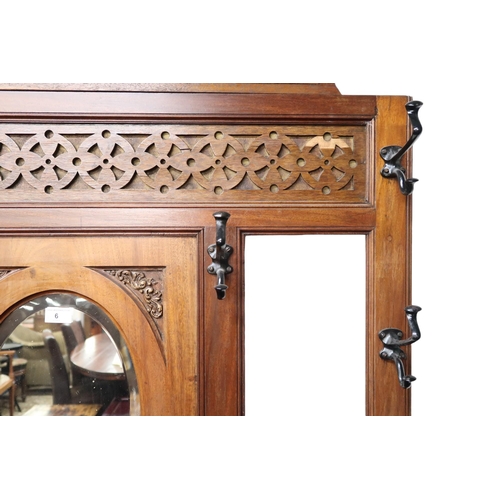 6 - An early 20th century mahogany and walnut veneered mirror backed hall stand with central oval bevell... 