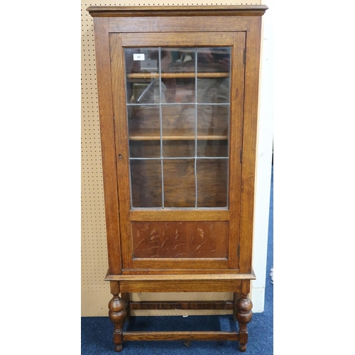 60 - An early 20th century oak bookcase with leaded glass door on turned supports joined by stretchers, 1... 