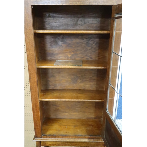 60 - An early 20th century oak bookcase with leaded glass door on turned supports joined by stretchers, 1... 