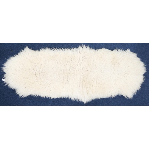 64 - A contemporary twinned pelt sheepskin rug approximately 180cm long x 60cm wide