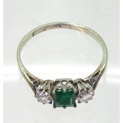 759 - An 18ct white gold and platinum emerald and diamond three stone ring, set with a square cut emerald ... 