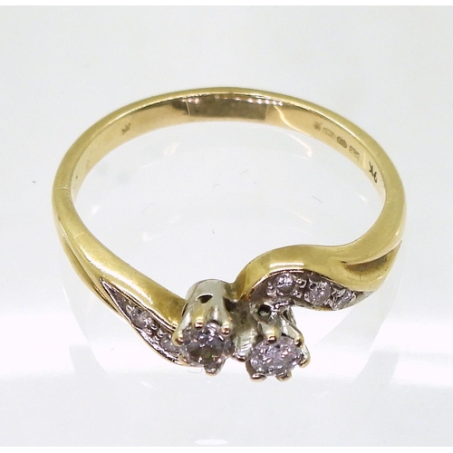 760 - A 9ct gold twin stone diamond ring on a twist, with further diamonds set to the shoulders with an es... 