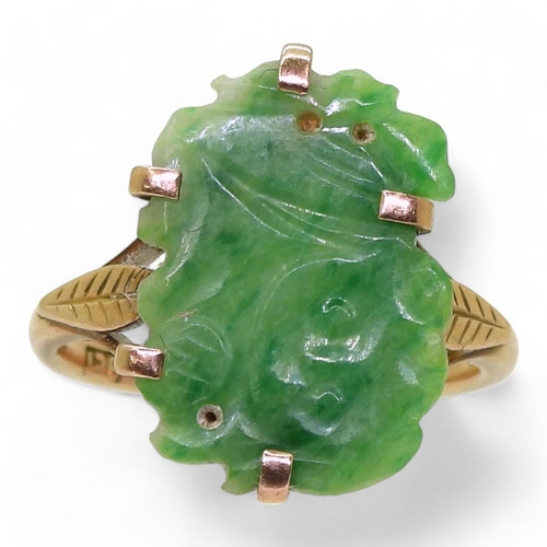 782 - A 9ct gold ring set with a Chinese green hardstone panel carved with a foo dog, finger size K1/2, we... 