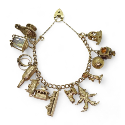 795 - A 9ct gold charm bracelet, with thirteen 9ct gold attached charms, weight 69.6gms