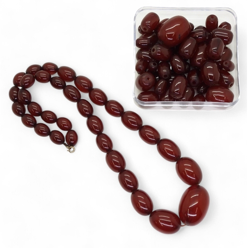 833 - A string of cherry amber beads, weight 52.2gms, together with loose cherry amber beads, weight 72.4g... 