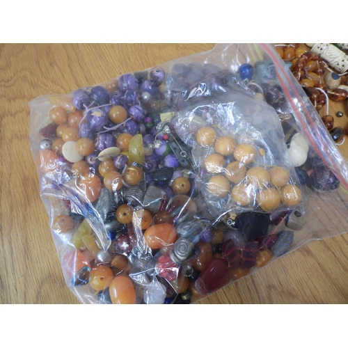 836 - A large collection of loose beads to include glass, faux amber, wood and metal vintage beads