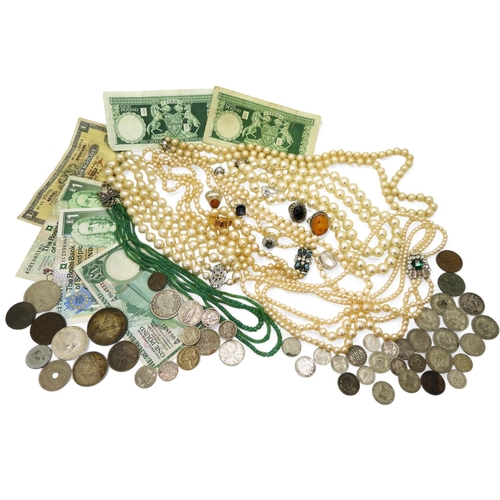 843 - A string of emerald beads, two silver mounted amber rings, a small selection of bank notes and  coin... 