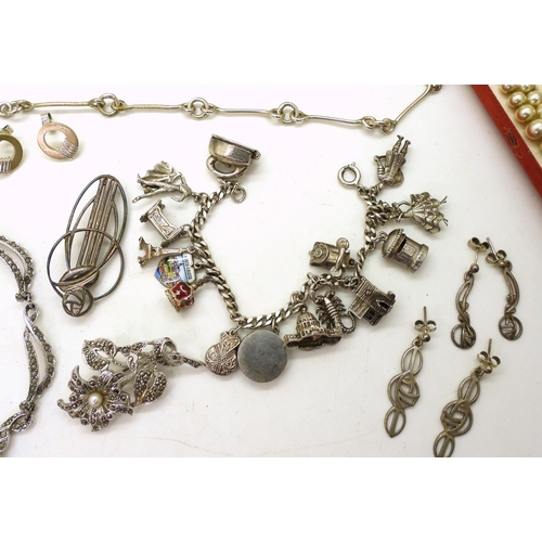 871 - A Silver charm bracelet with fifteen attached silver and white metal charms, a silver fancy baton li... 