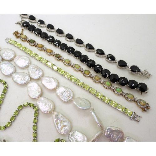 887 - A Peridot riviera necklace mounted in Silver, together with a string of flat pearls, an Opal bracele... 