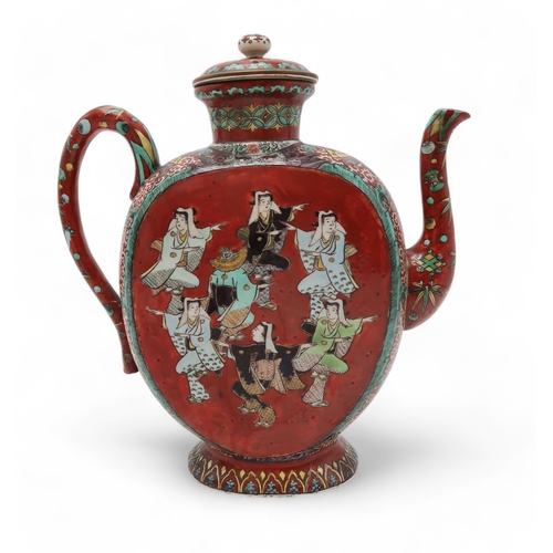 2415 - A KUTANI STYLE TEA KETTLE Painted with dancing figures on a red ground surrounded by demonic masks, ... 