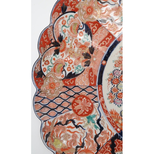 2420 - A LARGE IMARI CHARGER Painted with panels of flowers, Ho-o birds, diaper and mon decoration, 58cm di... 