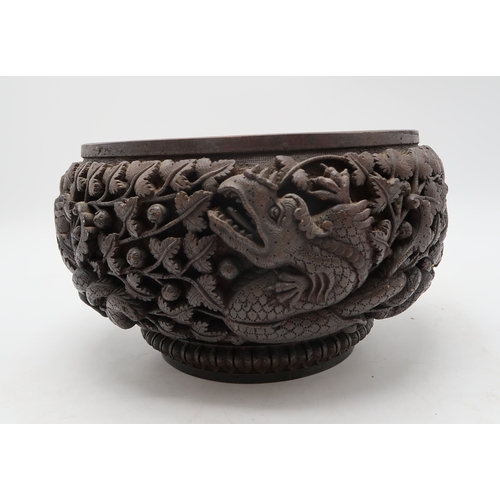 2423 - A BURMESE HEAVILY CARVED BOWL Decorated with dragons amongst dense foliage, 26cm diameter and lacque... 