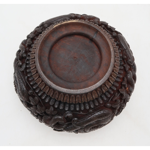 2423 - A BURMESE HEAVILY CARVED BOWL Decorated with dragons amongst dense foliage, 26cm diameter and lacque... 