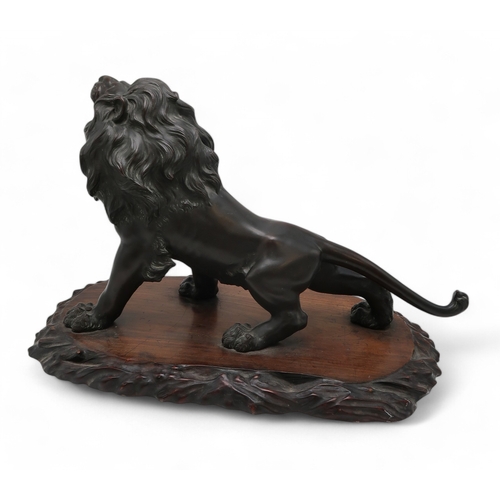 2427 - A JAPANESE BRONZE MODEL OF A ROARING LION Standing on all fours and mounted on a craved hardwood pla... 