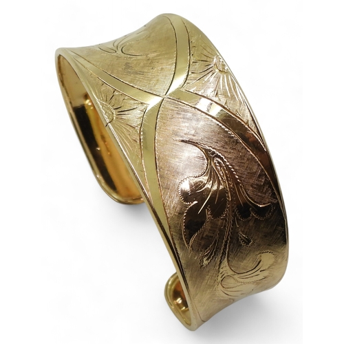 2722 - AN 18K GOLD BANGLEthe Italian made wide bangle has hand engraved floral detail throughout. Dimension... 