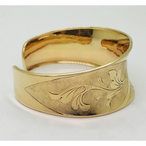 2722 - AN 18K GOLD BANGLEthe Italian made wide bangle has hand engraved floral detail throughout. Dimension... 