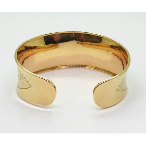 2722 - AN 18K GOLD BANGLEthe Italian made wide bangle has hand engraved floral detail throughout. Dimension... 