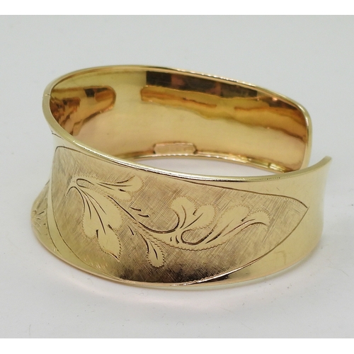 2722 - AN 18K GOLD BANGLEthe Italian made wide bangle has hand engraved floral detail throughout. Dimension... 