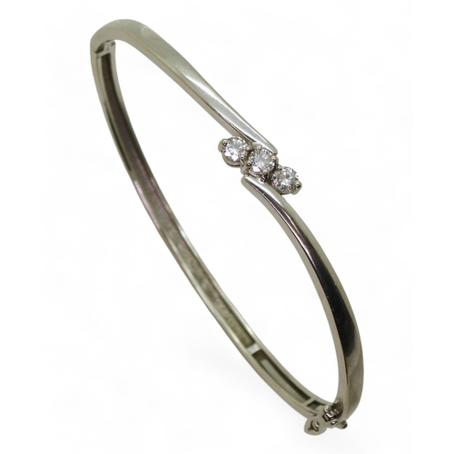 2734 - A DIAMOND BANGLEmounted in 9ct white gold and set with three brilliant cut diamonds, with a combined... 