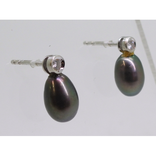 2744 - DIAMOND EARRINGSthe first pair in 18ct white gold set with drop shaped black pearls 9mm long, enhanc... 