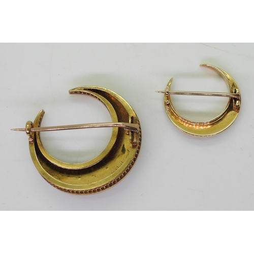 2766 - TWO CRESCENT MOON BROOCHESthe largest, made in bright yellow metal is set with cat's eye chrysoberyl... 