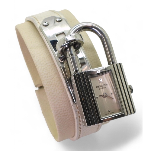 853 - A ladies Hermes Kelly watch, number KE1.210, issue number 2059285 with white leather strap, original... 