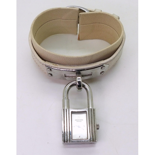 853 - A ladies Hermes Kelly watch, number KE1.210, issue number 2059285 with white leather strap, original... 