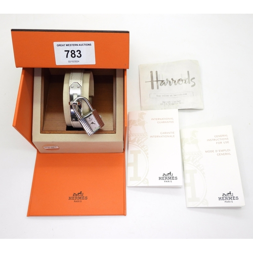 853 - A ladies Hermes Kelly watch, number KE1.210, issue number 2059285 with white leather strap, original... 