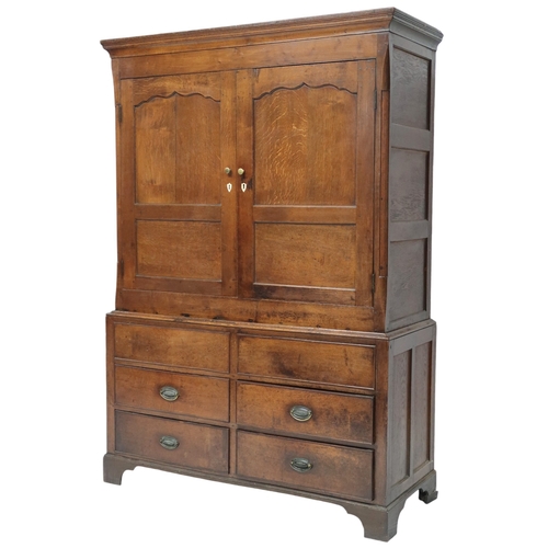 2024 - A LATE 19TH/EARLY 20TH CENTURY OAK LINEN PRESS/WARDROBE with cornice over pair of panelled door... 