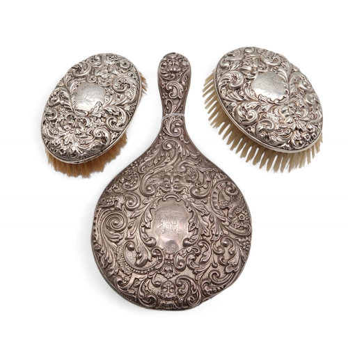 375 - A three piece silver dressing set, by Walker & Hall, Sheffield 1908, with cast grotesque mask an... 