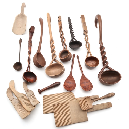 515 - A large collection of treen, to include butter pats, spiral twist-handled ladles, glove stretchers i... 