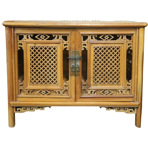 11 - A small 20th century Oriental hardwood side cabinet with stylistic pierced doors and sides on shaped... 