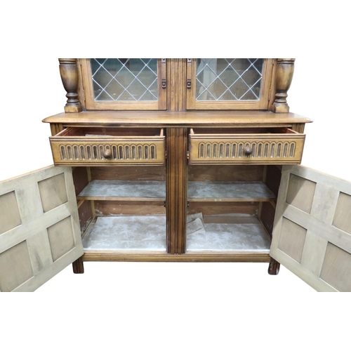 14 - A 20th century beech court cabinet with pair of leaded glass doors over two drawers over pair of pan... 