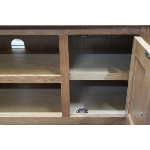 56 - A contemporary white oak coffee table with two open shelves flanked by cabinet doors on square taper... 