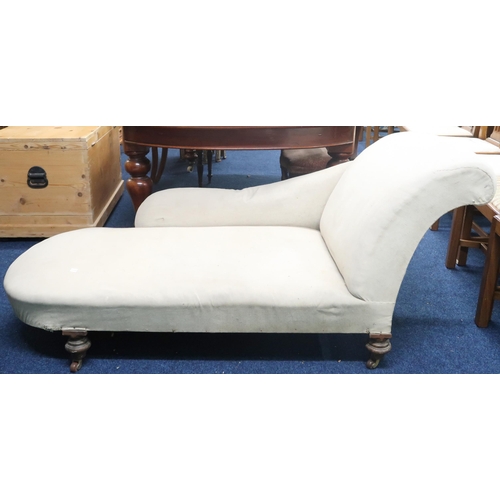 80 - A Victorian cream upholster chaise longue with sweeping back rest on turned supports terminating in ... 