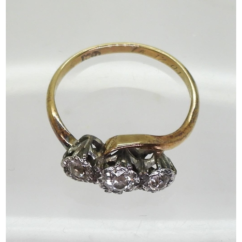 711 - An 18ct gold three stone diamond ring on a twist, set with estimated approx 0.25cts of old cut diamo... 