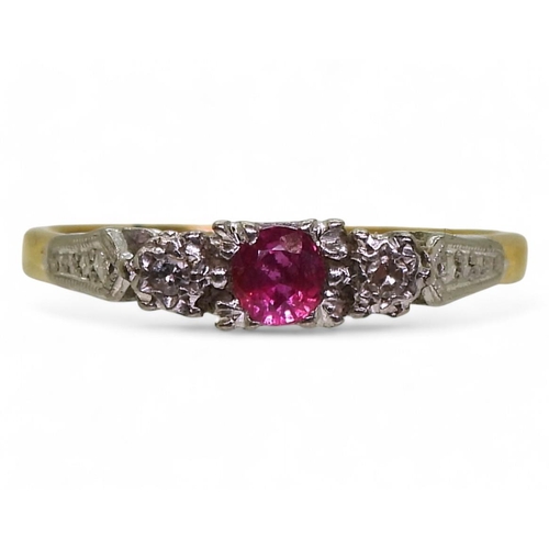 723 - An 18ct gold and platinum vintage ring set  with a ruby and two diamonds, in illusion star sett... 