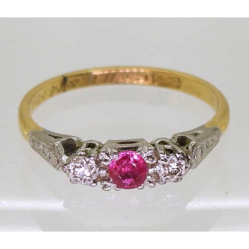 723 - An 18ct gold and platinum vintage ring set  with a ruby and two diamonds, in illusion star sett... 