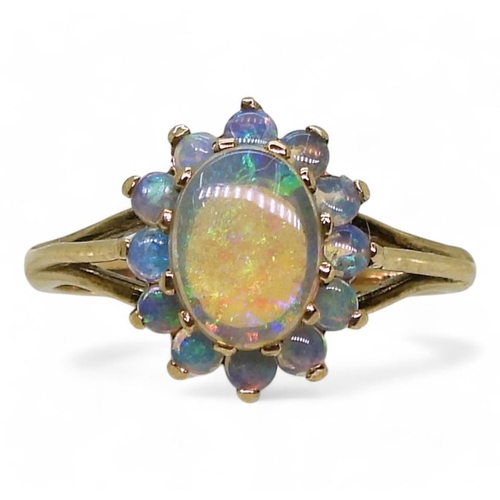 767 - A 9ct gold black opal cluster ring, the central opal 8mm x 6mm x 1.9mm, size L1/2, weight 2.2gms