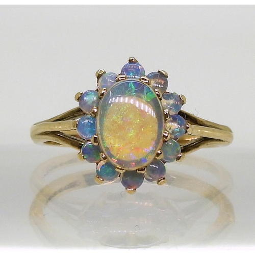 767 - A 9ct gold black opal cluster ring, the central opal 8mm x 6mm x 1.9mm, size L1/2, weight 2.2gms