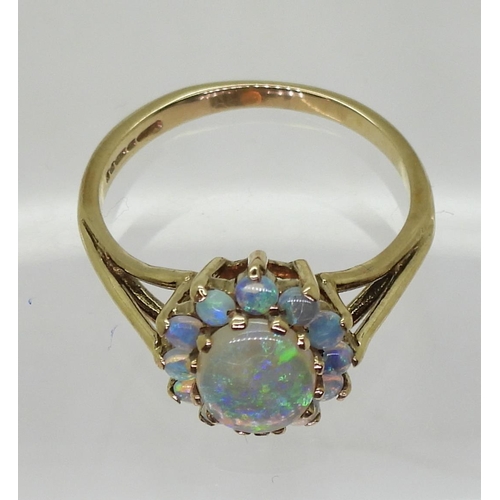 767 - A 9ct gold black opal cluster ring, the central opal 8mm x 6mm x 1.9mm, size L1/2, weight 2.2gms