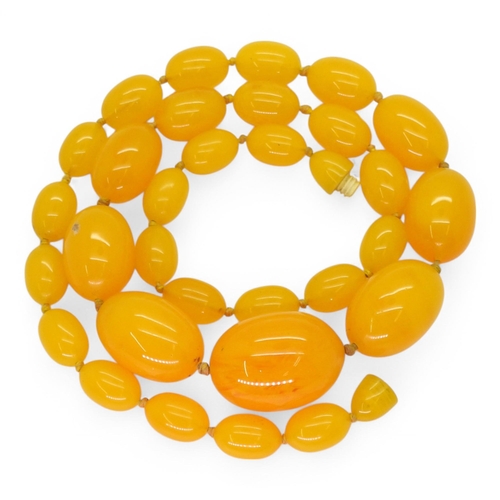 780 - A string of yellow amber coloured beads, the largest approx 3.5cm x 2.6cm, with overall fine crazing... 