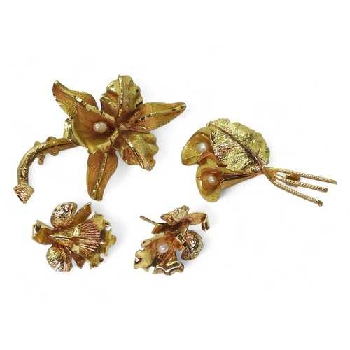 822 - An orchid brooch and earrings, and an arum lily brooch. Handmade, all stamped 18k, and set with fres... 