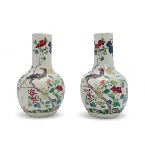 2455 - A PAIR OF CHINESE FAMILLE ROSE BALUSTER SHAPED VASES Painted with peacocks amongst flowering branche... 