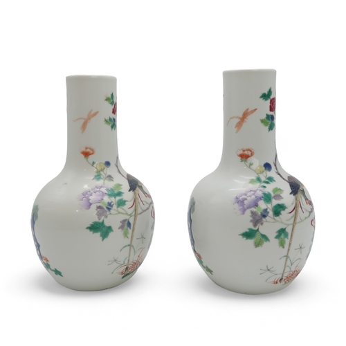 2455 - A PAIR OF CHINESE FAMILLE ROSE BALUSTER SHAPED VASES Painted with peacocks amongst flowering branche... 